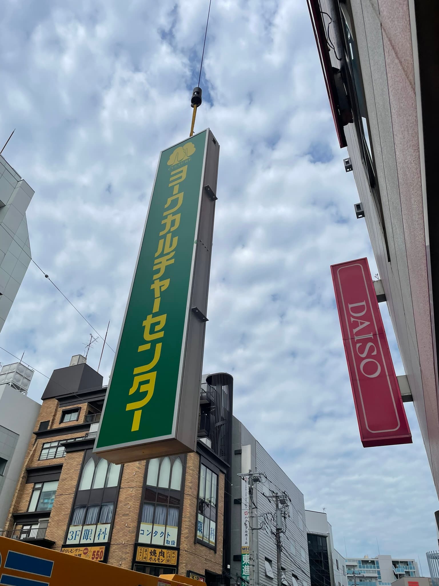 クレーンで看板を吊り上げる施工風景